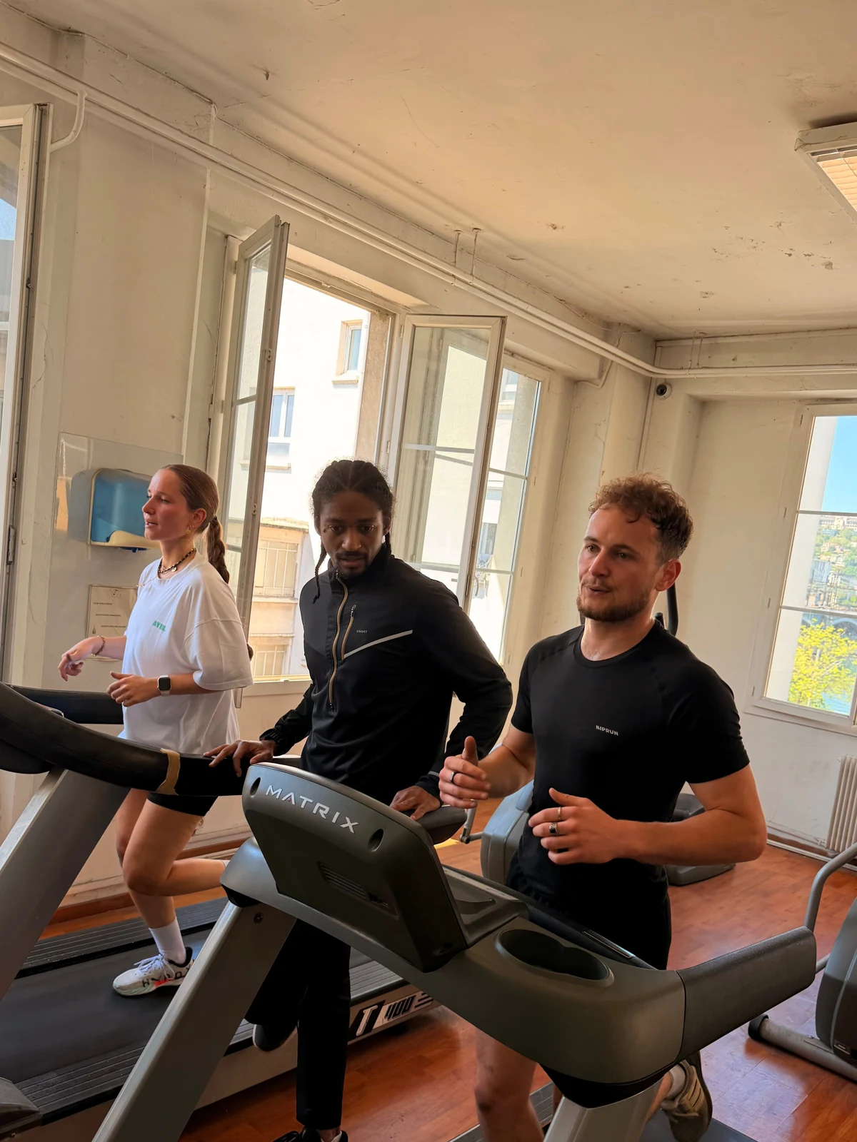 Harry accompagne deux élèves pendant leur entraînement sur tapis